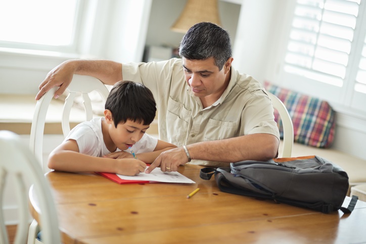 Father helping won with homework at title