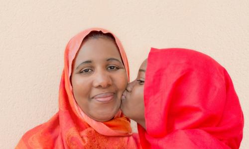 Young daughter kissing mother