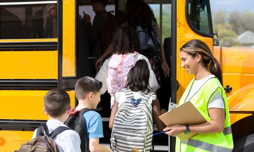 School bus driver greeting students