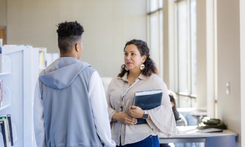 Teacher talking to a student in the hallway