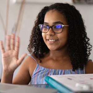 Girl waving at computer