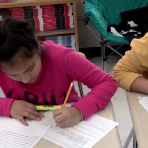 a girl writing at her desk
