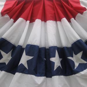 A fan of cloth decorated in red, white, and blue bands with stars on the blue.