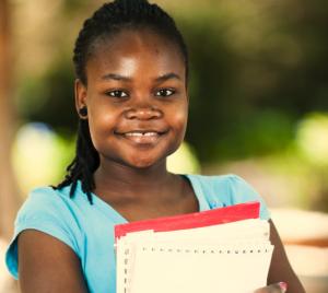 girl smiling at camera holding books