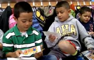 two young kids holding square pieces of paper in their hands