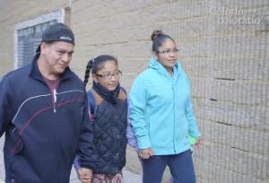 two adults walking with a young girl