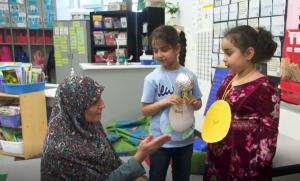Students present science project to teacher