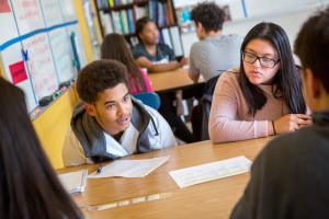 boy talking with other students at a table