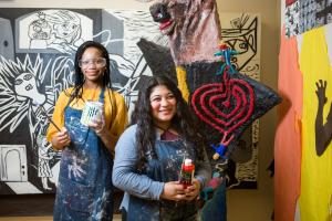 Art student in front of a mural