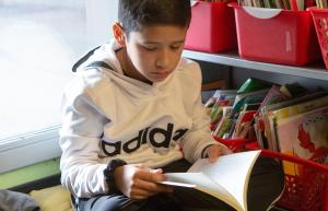 Boy reading near book bins