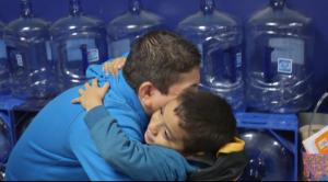 A man hugging a boy.