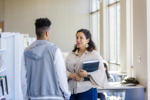 Teacher talking to a student in the hallway