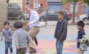 A man playing soccer with a bunch of boys.