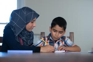 Muslim mother helping son with homework