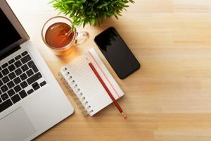 Computer, notebook, and cup of tea