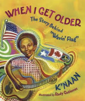 K'NAAN holding a guitar as a child