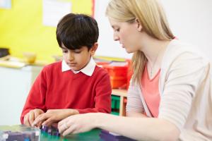 woman sitting with boy working on something on the table