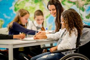A woman helping a young girl with her schoolwork.