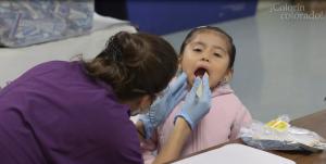 Dental student checking child's teeth, Wolfe Street Academy in Baltimore (MD)