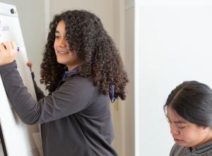 Student writing on poster board