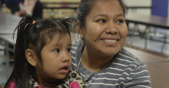 Mother holding a daughter at the school cafeteria