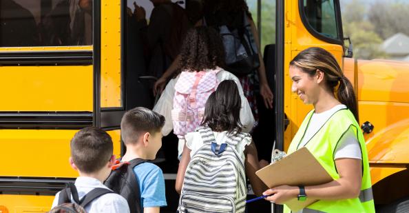 Bus driver greeting students