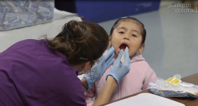Dental student checking child's teeth, Wolfe Street Academy in Baltimore (MD)