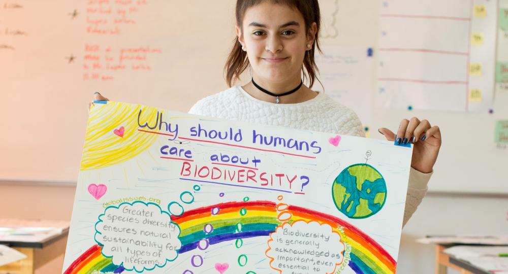 Student holding biodiversity poster